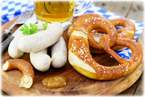 Ein Holzbrett, auf dem verschiedene Nahrungsmittel liegen. Daneben ein Bier.