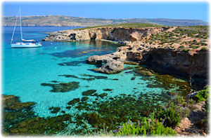 Ein Blick auf eine wunderschöne Bucht in Comino, mit einer Yacht.