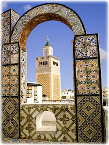 Ein Turm, vor dem eine Art verzierter Bogen steht.