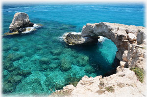 Ein Fels im Wasser, der wie eine Brücke aussieht.