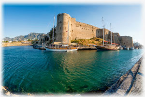 Ein altes Schloss bzw. eine alte Burg, an der ein historischer Hafen angrenzt.